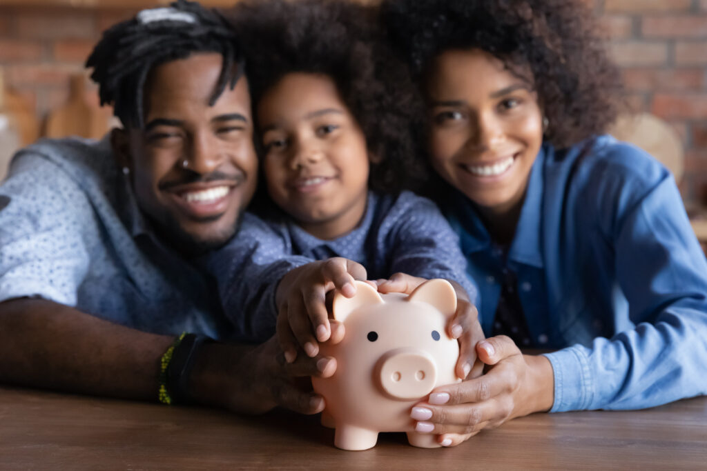 Multiracial family touching piggy bank