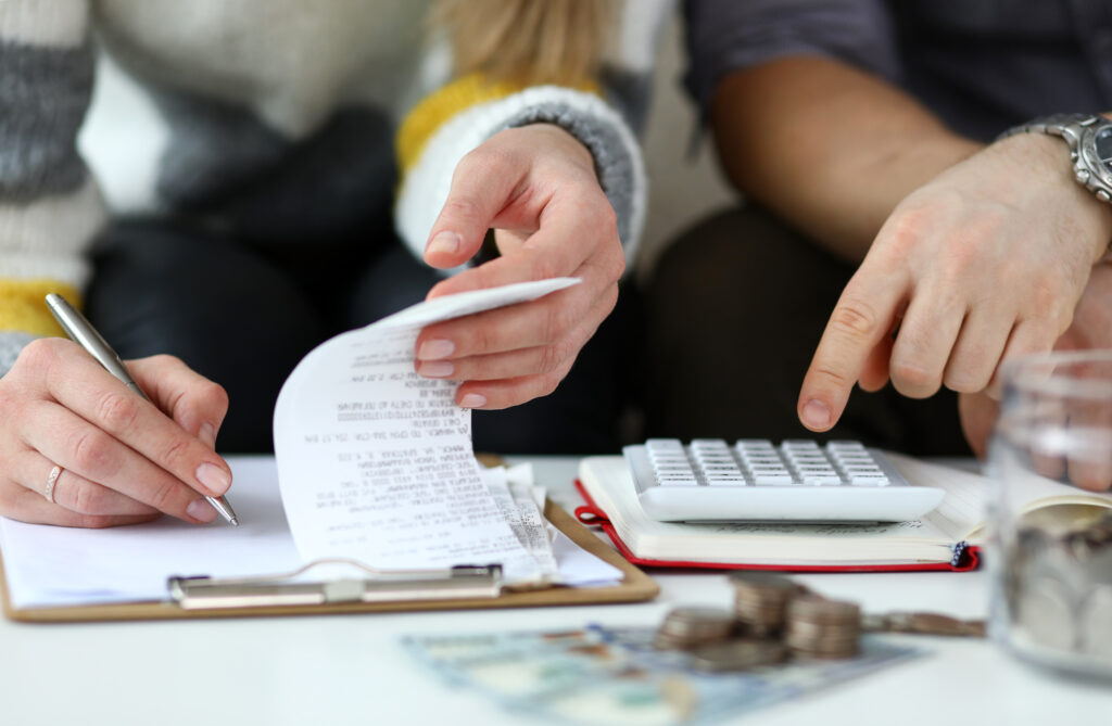 Two people with calculator and receipts, financial planning, cash flow